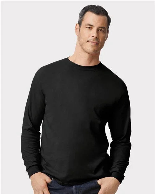 Man wearing a black long-sleeve shirt against a light gray background